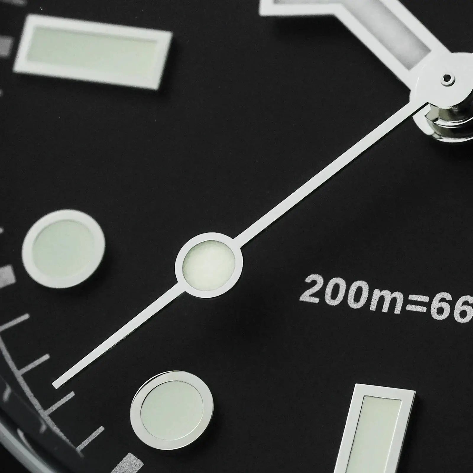 Analog watch dial close-up with white luminous markers on a black background