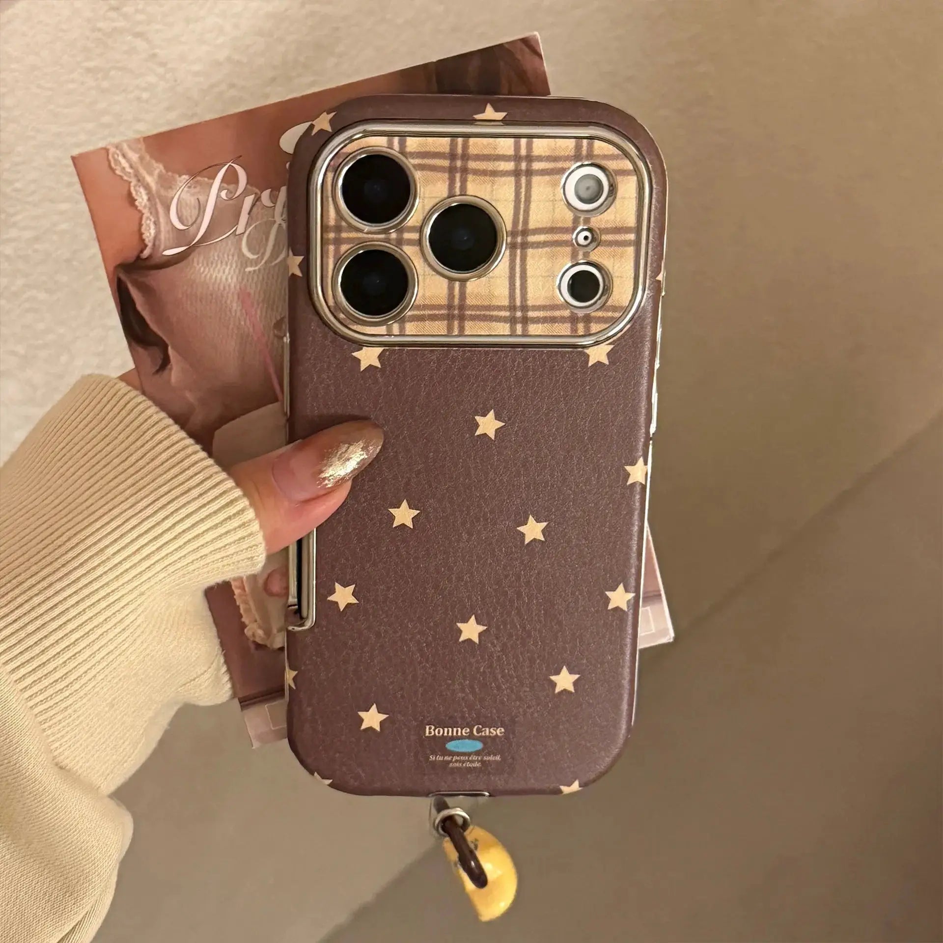 Phone case with brown leather texture, plaid inner, star accents and pendant strap; shockproof for iPhone Pro Max