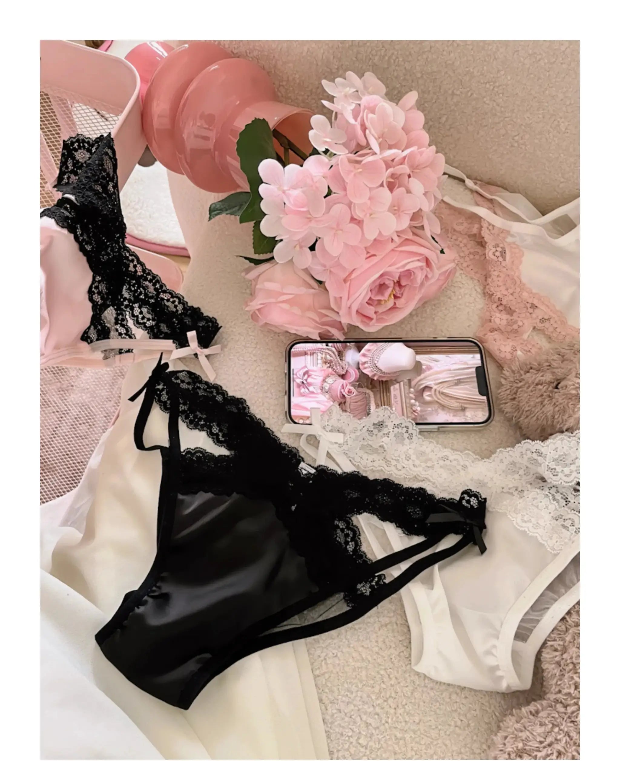 Simples Market black lace lingerie set with sheer mesh panels and bows; pink satin pieces and a smartphone shown