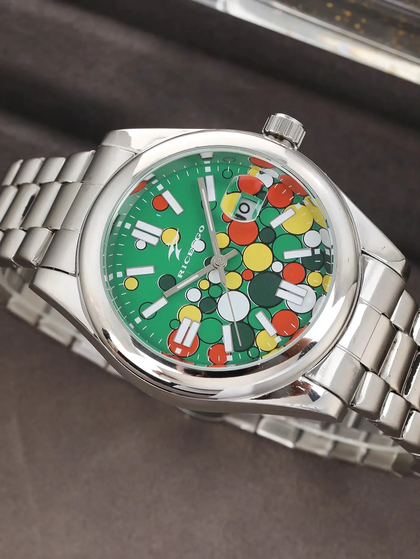 Classic men's quartz watch; stainless steel case/bracelet, green dial with multicolor circles and date window.