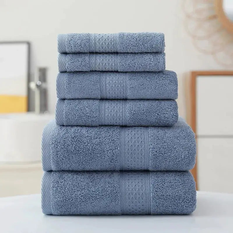 Blue cotton towel set stacked with five towels; ultra-soft and highly absorbent for bathroom.