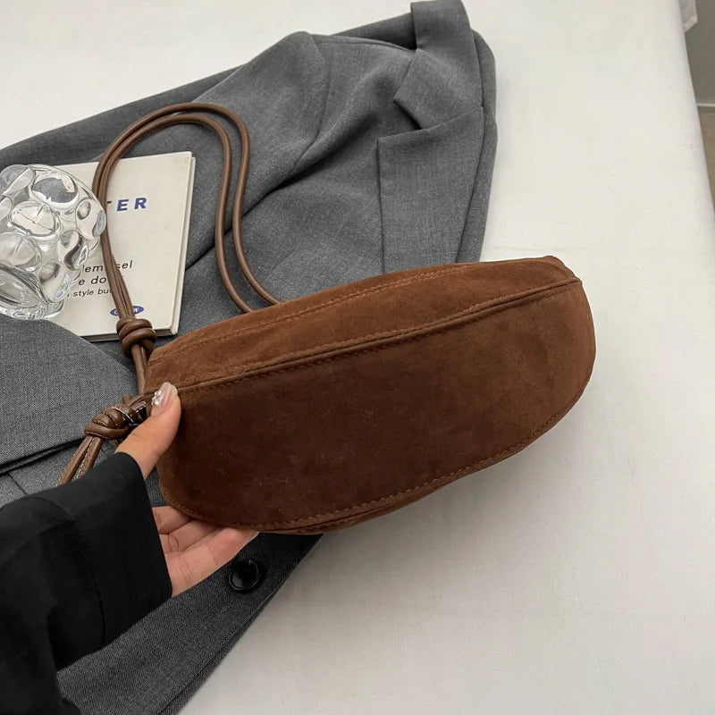 Faux suede shoulder bag in brown with long crossbody strap and dumpling oval silhouette