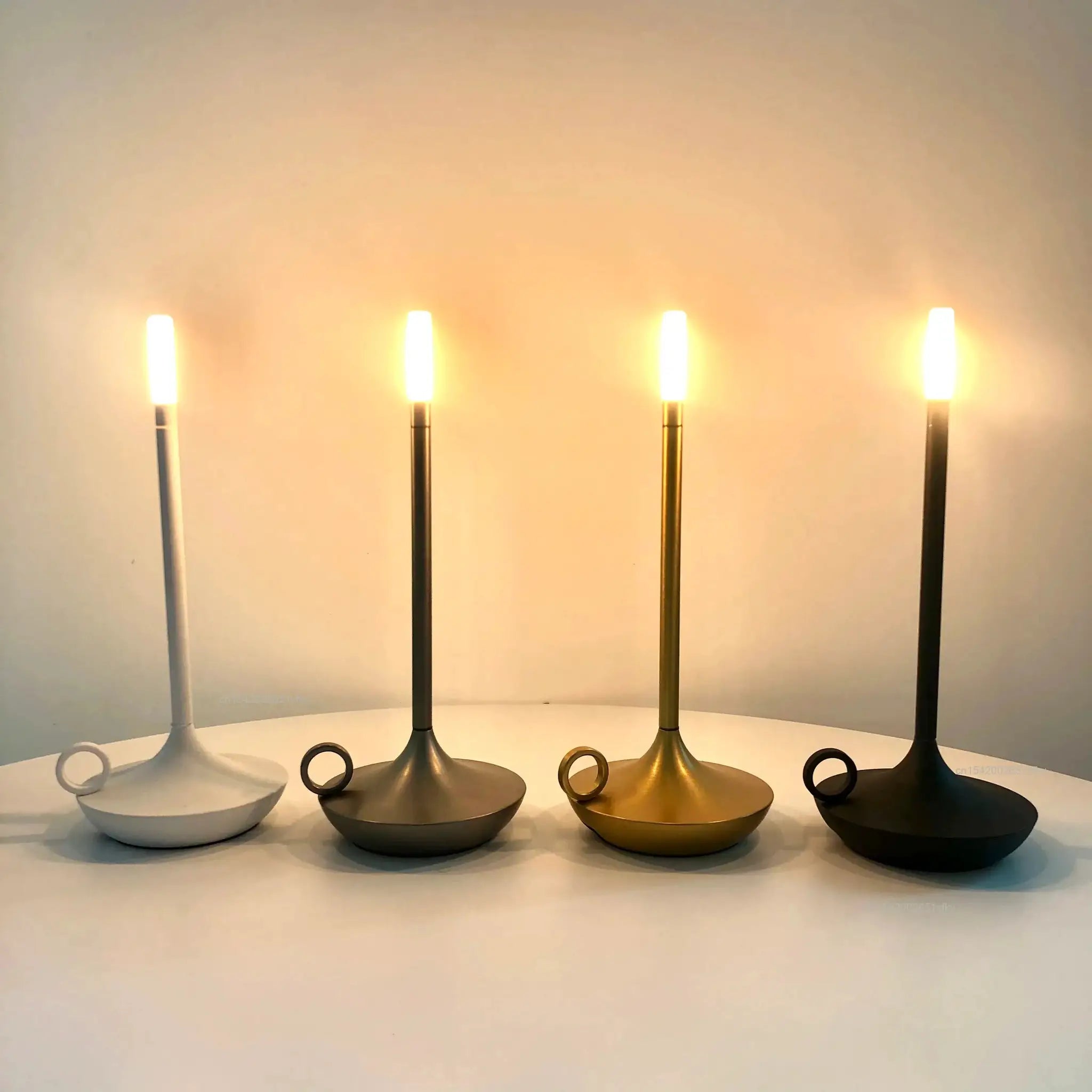 Atmosphere LED candle USB desk lamp set of 5 in white, black, gold, bronze and gunmetal on round bases.