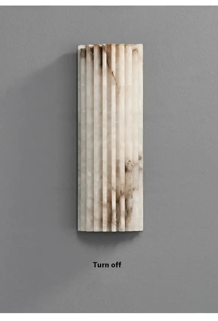 Modern minimalist marble wall lamp with vertical ribbed panels in white with brown veining.