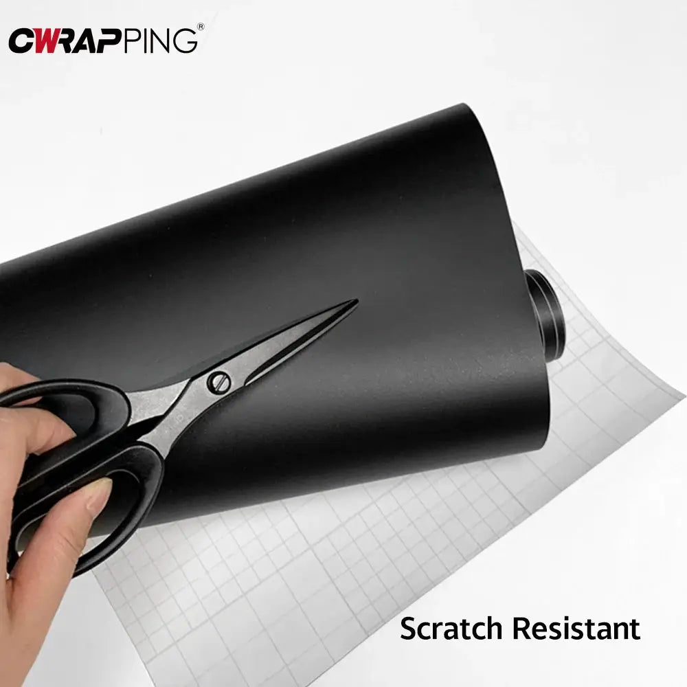 Matte black PVC vinyl wrap sheet by CWRAPING being cut with scissors; scratch resistant