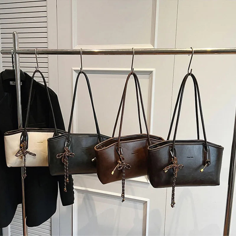 Set of 4 Simples Market PU leather shoulder bags in cream, gray, brown, and black with tasseled cords.