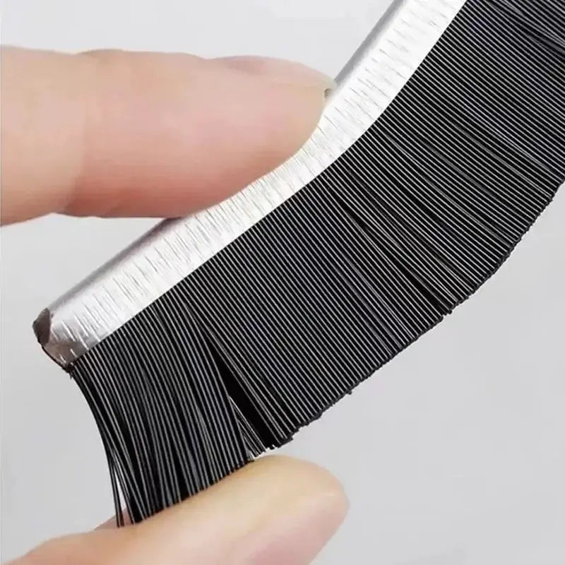 Grout gap cleaning brush with hard black bristles and a silver spine for cleaning tile joints.
