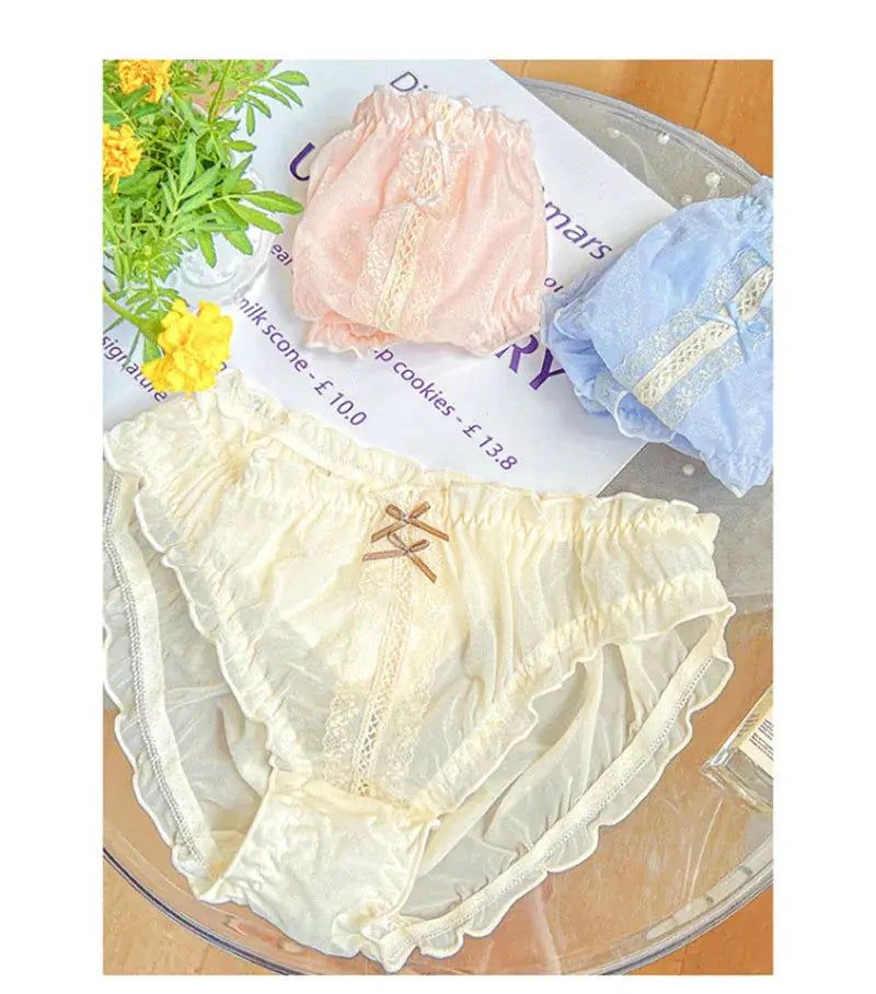 Panties set: three-piece lace-trimmed underwear in cream, peach, and blue with bows and ruffles.