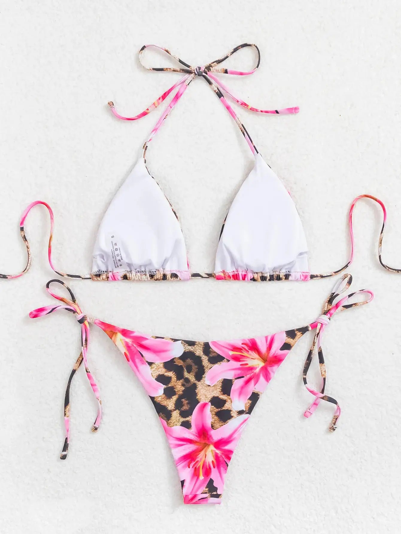 Bikini set, two-piece white triangle top with pink floral straps and leopard-print bottoms with side ties.