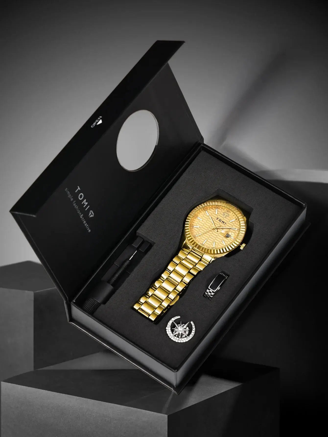 TOMI men's gold-tone quartz watch gift set in black box with stainless steel strap; includes ring and compass pendant.