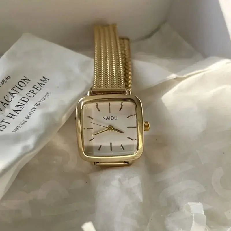 Gold-tone NAIDU women's quartz wristwatch with a square face and stainless steel mesh band