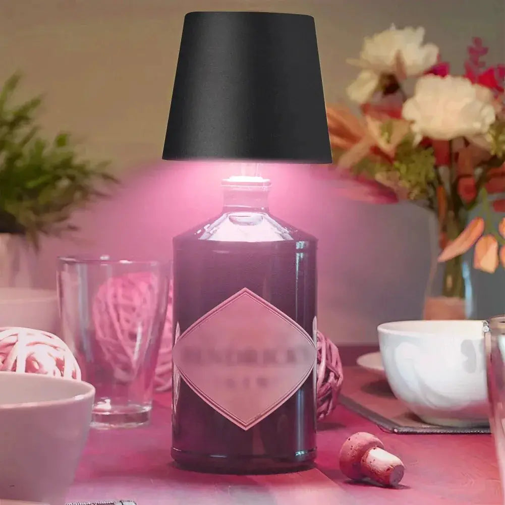 Wireless table lamp for wine bottles by Simples Market with black shade and pink LED glow