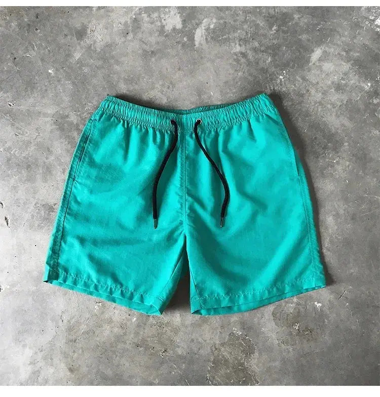 Men's turquoise swim shorts with black drawstring and elastic waistband