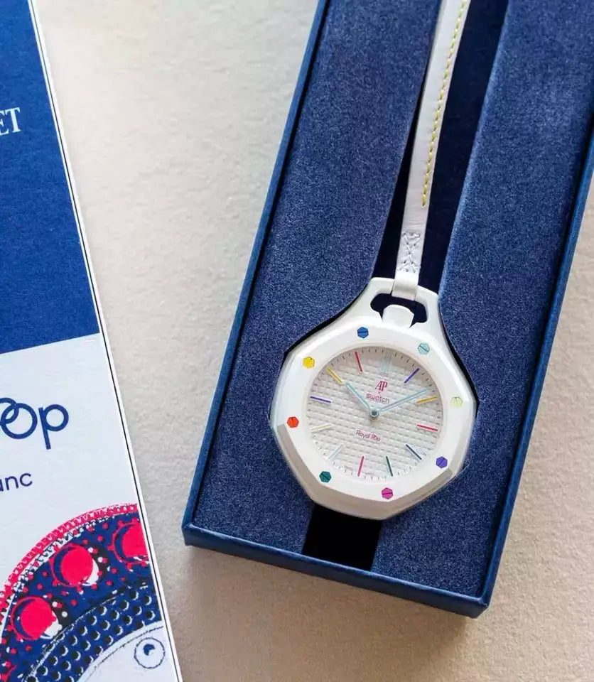 White quartz wristwatch with multicolor gemstone bezel and white strap in a blue gift box