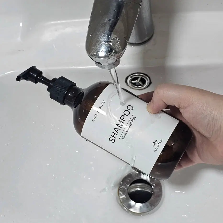 Shampoo dispenser bottle, brown with white label, 500ml, black pump under running faucet