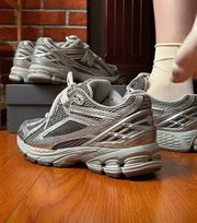 Grey retro dad sneakers with breathable mesh and chunky sole; multiple pairs on a wooden floor.