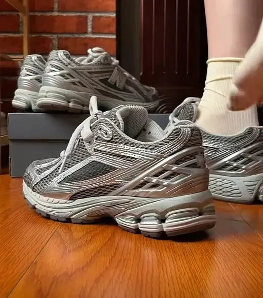 Grey retro dad sneakers with breathable mesh and chunky sole; multiple pairs on a wooden floor.