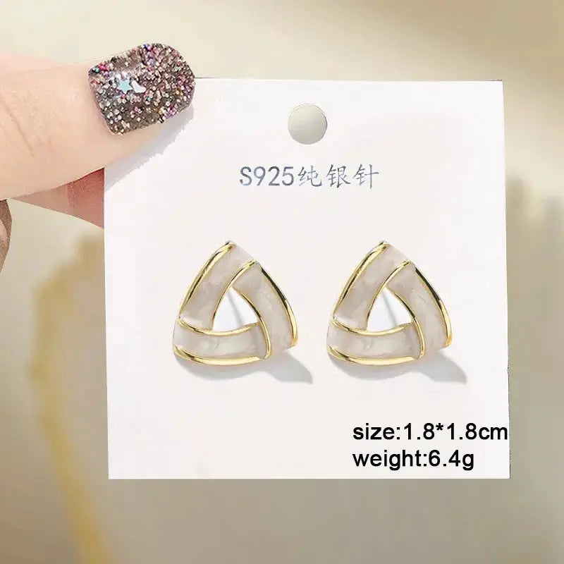 Triangle white enamel earrings with gold-tone trim and sterling-silver posts by Simples Market, pair