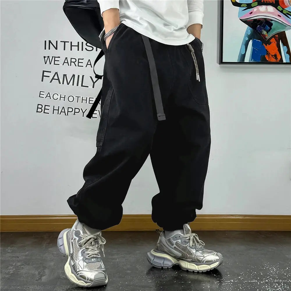 Baggy cargo pants for men, black streetwear joggers with drawstring waist and pockets, paired with chunky sneakers