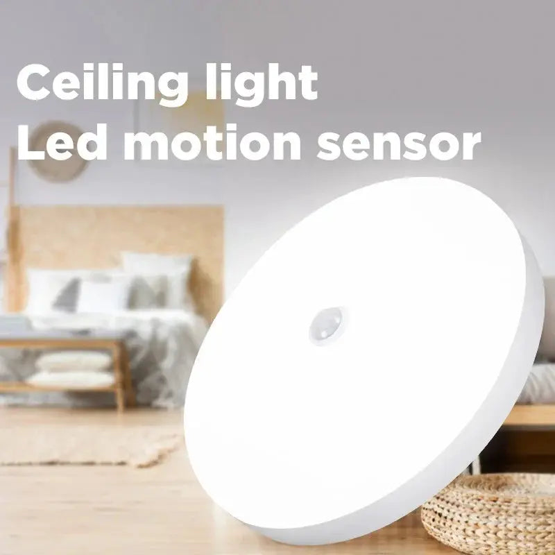 Round white LED motion-sensor ceiling light fixture in a bedroom.