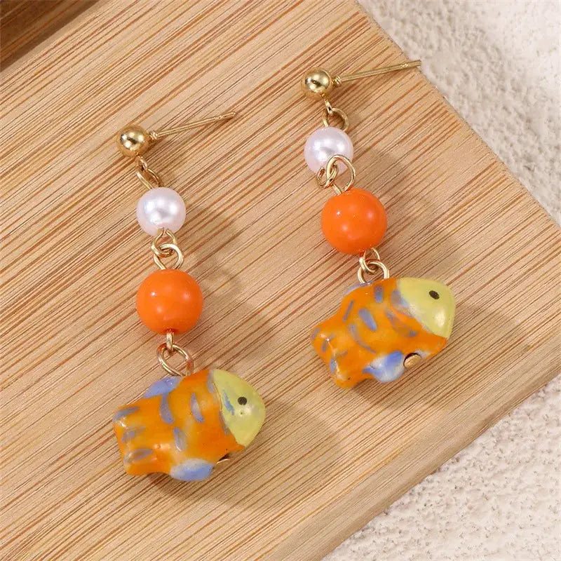 Pair of cute octopus glass drop earrings with orange-yellow octopus charms, pink pearls and gold findings