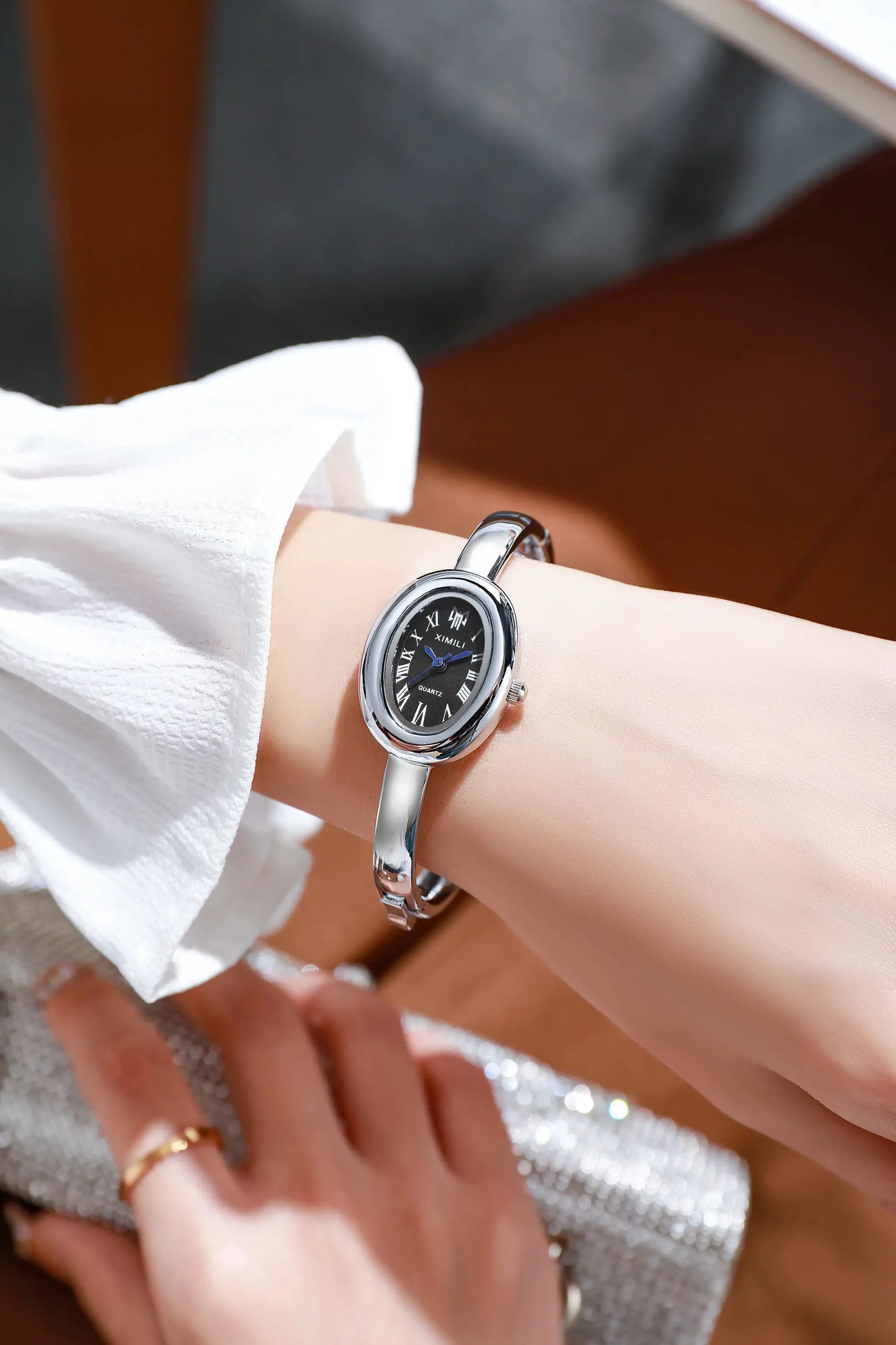 Women's luxury quartz watch from Simples Market with silver steel bracelet and black Roman-numeral dial