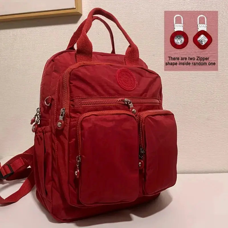 Backpack Simples Market waterproof red nylon with top handles and multiple zip pockets.
