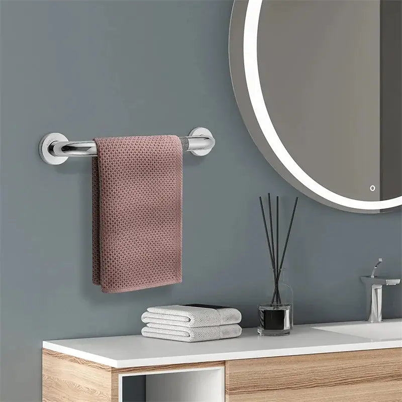 Stainless steel bathroom grab bar with towel rack, wall-mounted with pink towel.