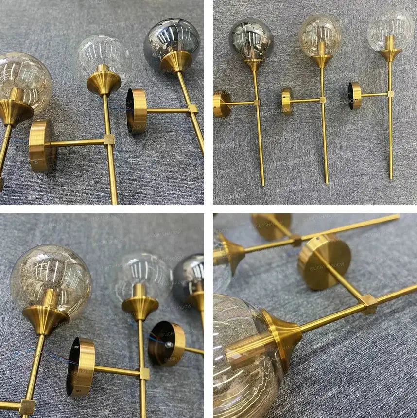 Modern glass wall lamp four-light brass gold sconce with globe bulbs.