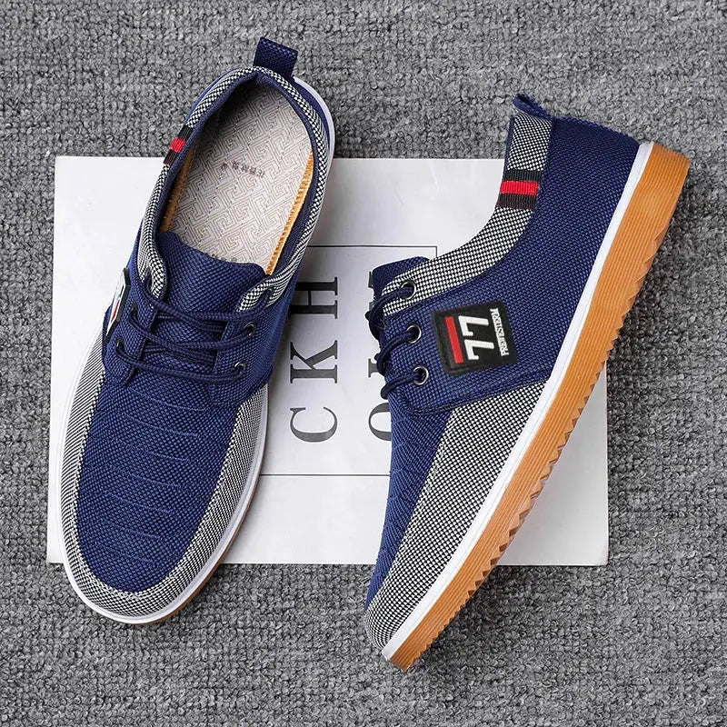 Two navy blue knitted men's casual sports shoes with gray panels and gum outsole.