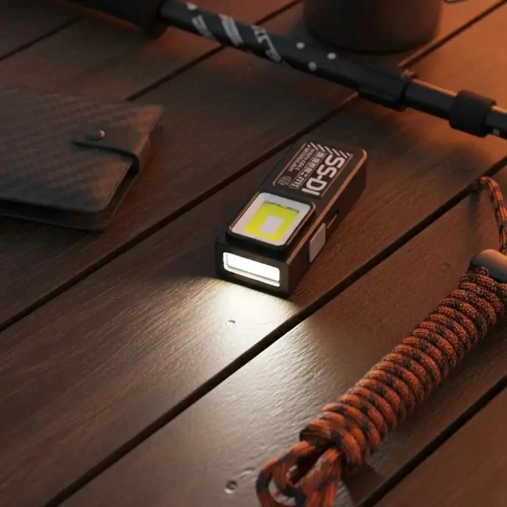 Powerful mini COB LED keychain flashlight with USB-C recharge, black body and paracord lanyard
