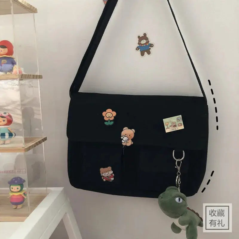 Women's black canvas messenger bag by Simples Market with bear prints and hanging keychain
