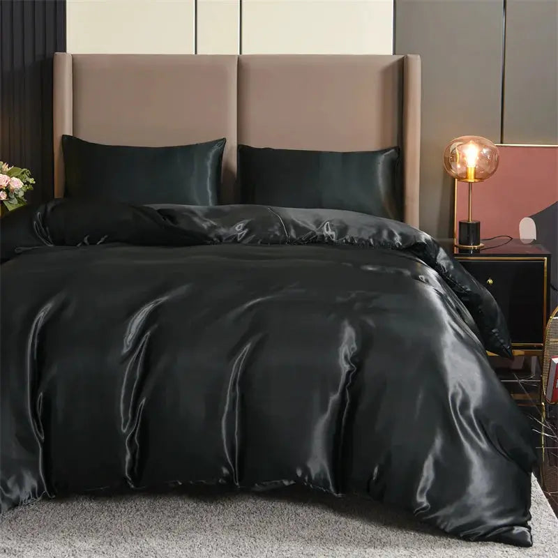 Simples Market 3pc satin duvet cover set in black with matching pillowcases on a bed.