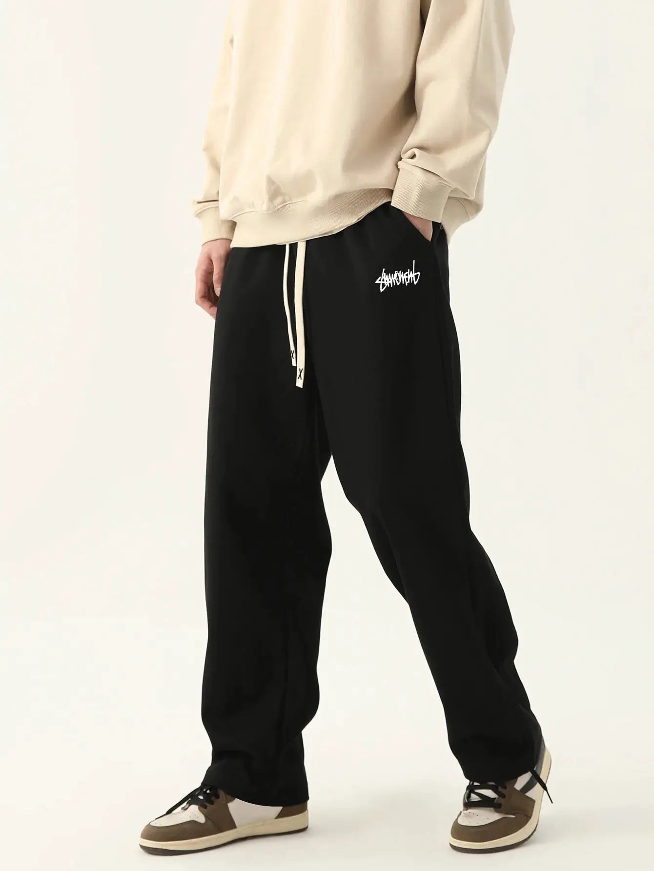 Men's jogging pants by Simples Market, black baggy style with white logo and drawstring waist.