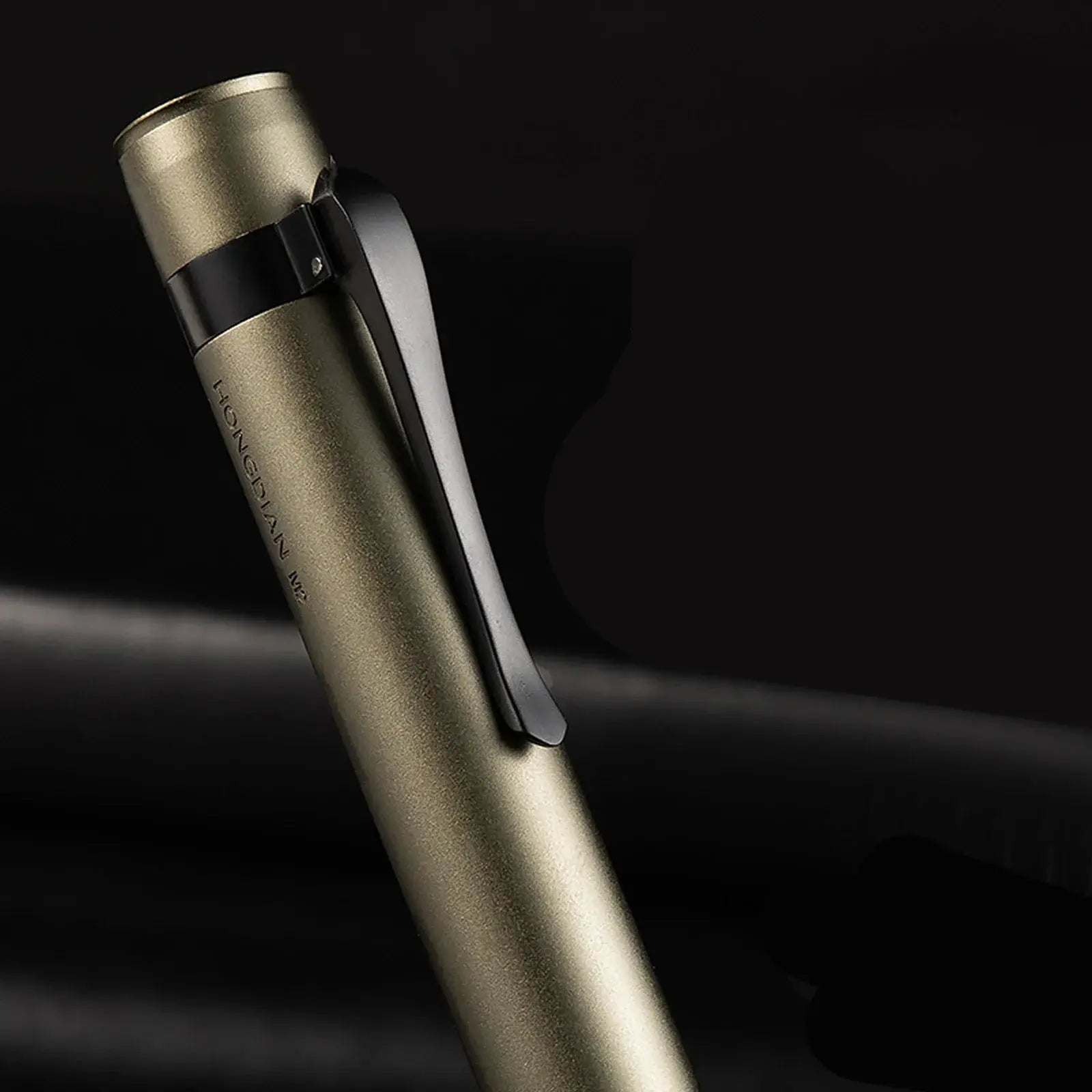 Hongdian M2 fountain pen, mini gold-tone body with black clip, close-up