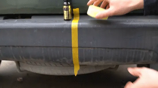 Car plastic restorer ceramic coating by Simples Market applied to black bumper trim with yellow masking tape nearby