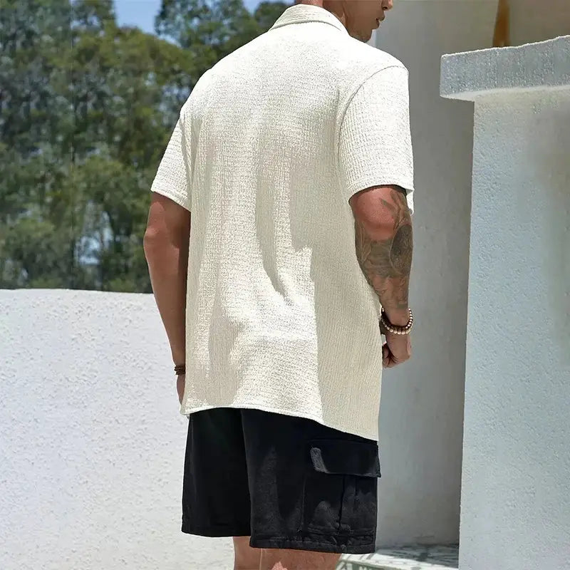 Men's casual short-sleeve shirt in cream textured fabric with a baggy fit; black cargo shorts