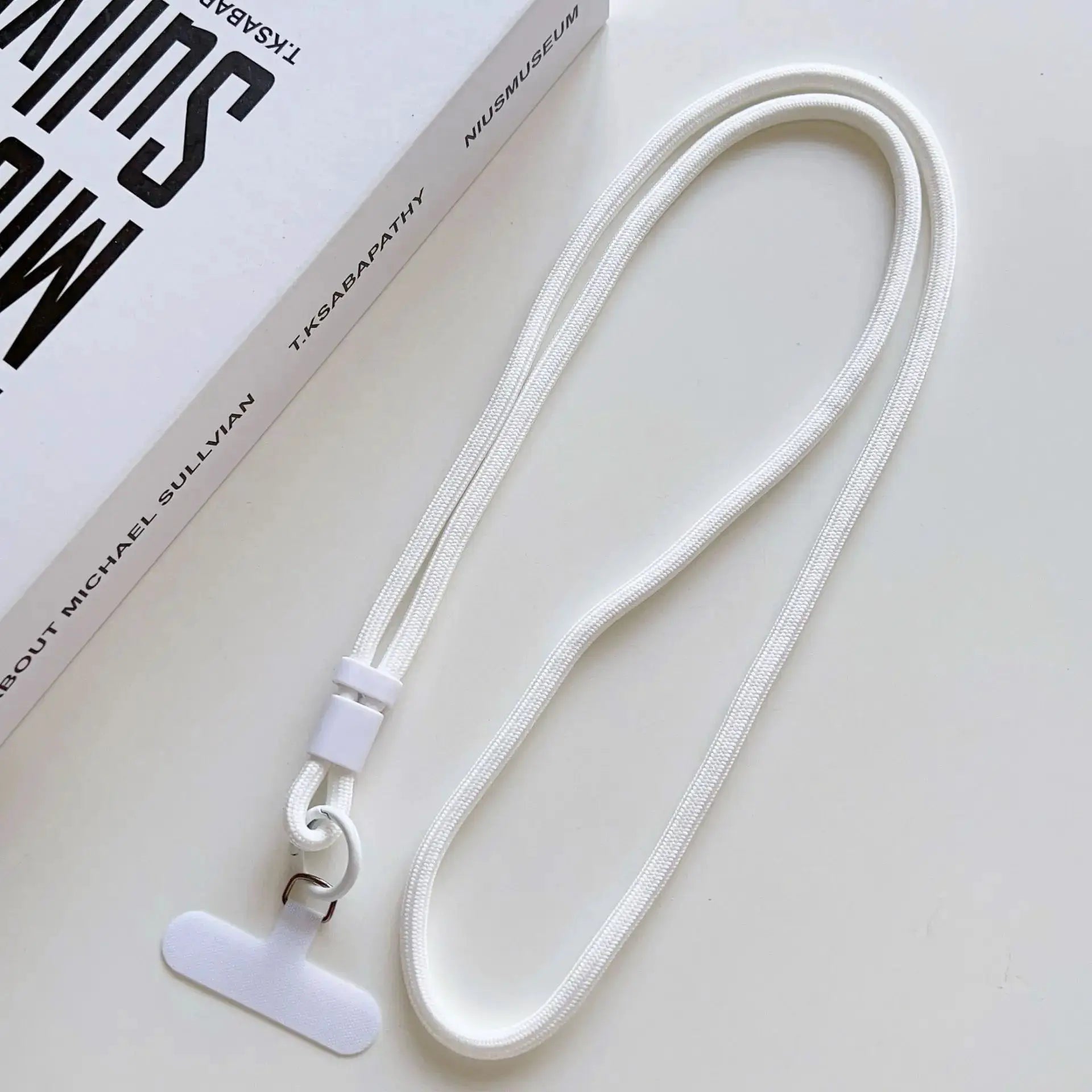 White braided mobile phone lanyard with adjustable plastic clasp and metal ring; Michael Sullivan packaging