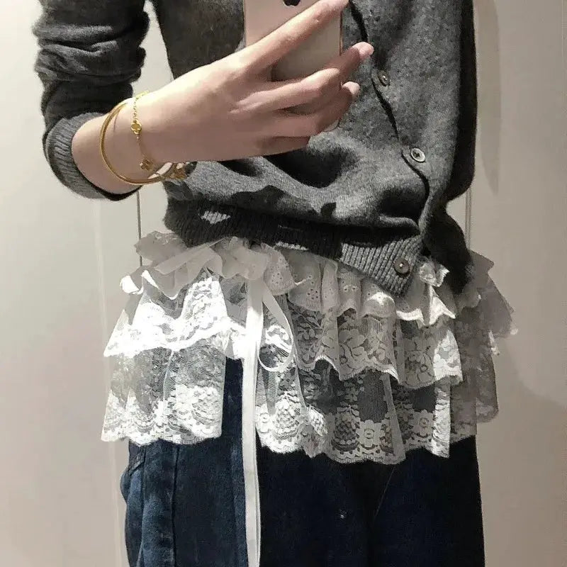 Women’s lace mini layered skirt with tiered white lace ruffles and ribbons, shown with a grey knit top