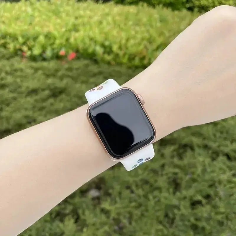 Simples Market silicone sport strap for Apple Watch, white with rainbow Pride accents, fits 38–45mm, shown on wrist