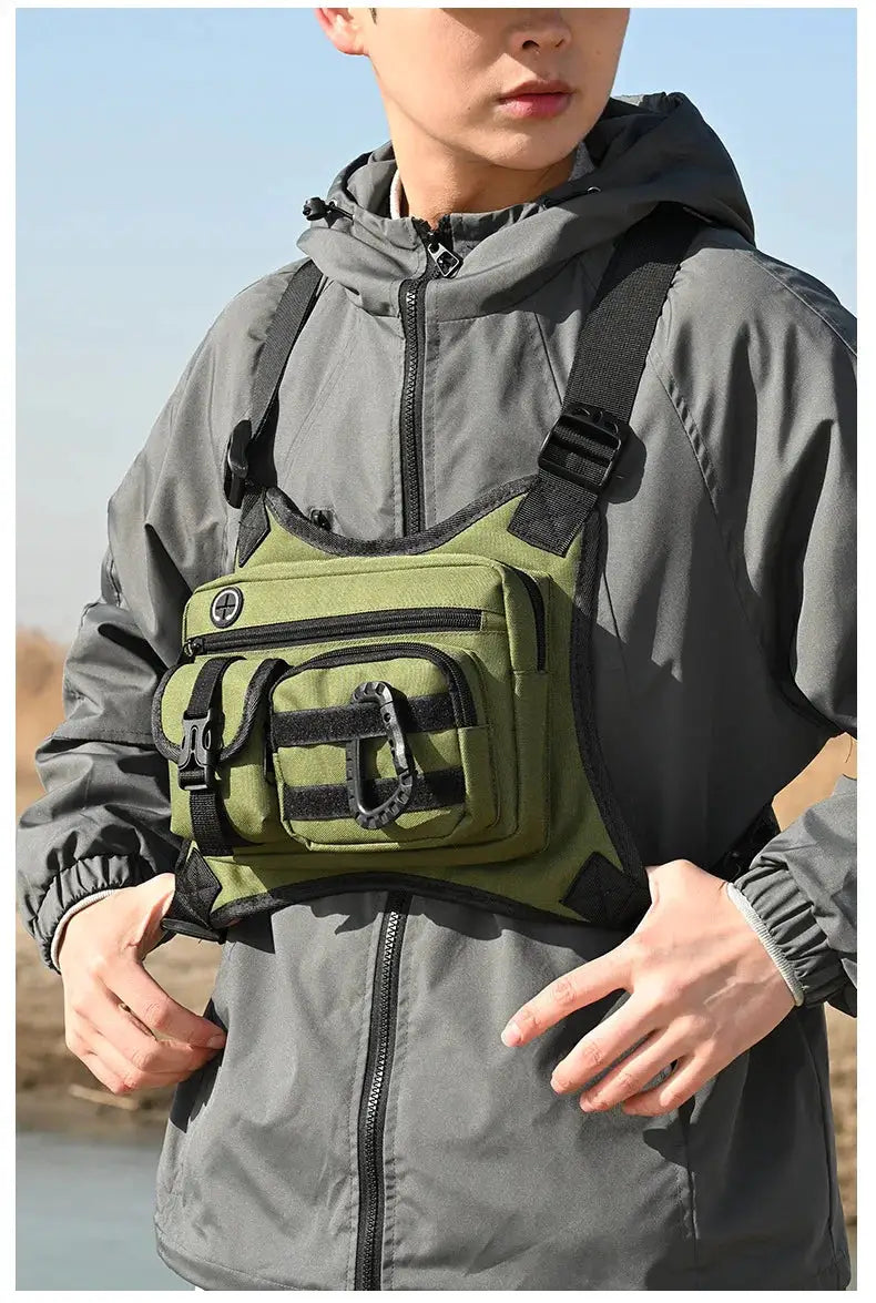 Outdoor tactical chest bag olive green with black straps and multiple pockets worn across a gray jacket