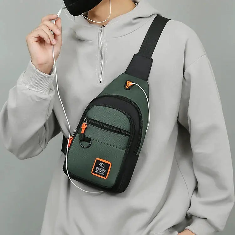 Simples Market men's crossbody hiking bag, green with black trim and orange zipper pulls