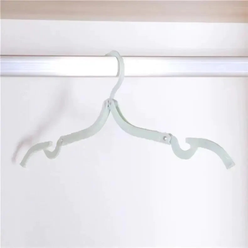 Foldable portable clothes hanger, white, ideal for travel and home storage.