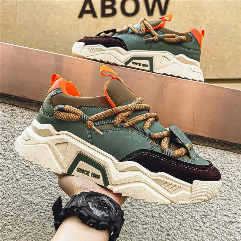 Pair of men's casual sneakers, olive-green low-top with orange accents and chunky beige sole