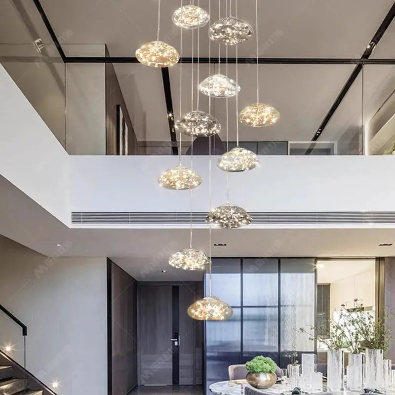 Pendant lights by Simples Market; modern glass dome hanging chandeliers cascading in a living/dining area