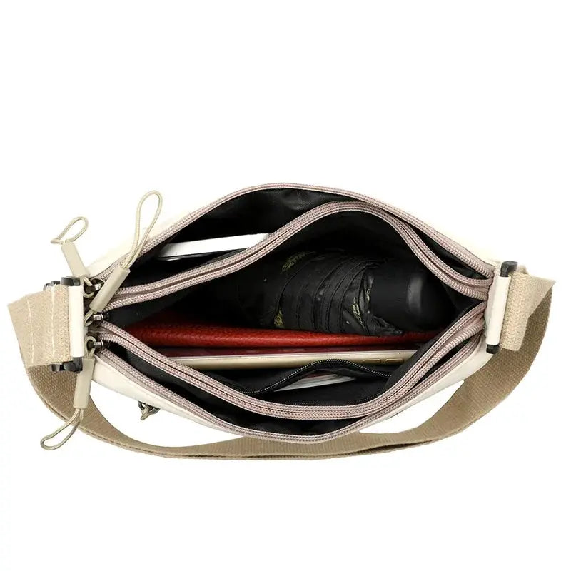 Simples Market beige canvas shoulder crossbody bag with 3 main pockets, opened to show contents.