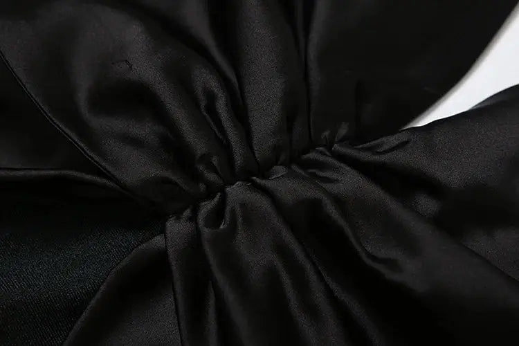 kliou black satin jumpsuit with waist knot detail; close-up fabric texture