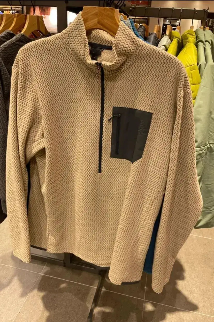Beige wavy-fleece pullover with stand collar, half-zip front and black zip chest pocket