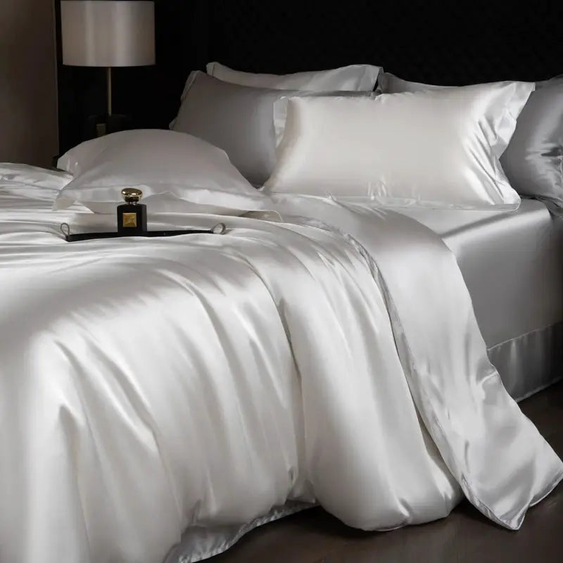 Silk bed sheets set by Simples Market in white satin; includes duvet cover, fitted and flat sheets with pillowcases.