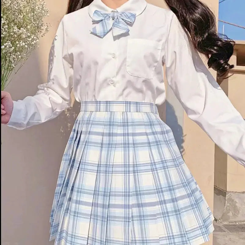 ZOKI plaid women pleated skirt in blue plaid, high-waist; shown with white blouse and blue plaid bow.